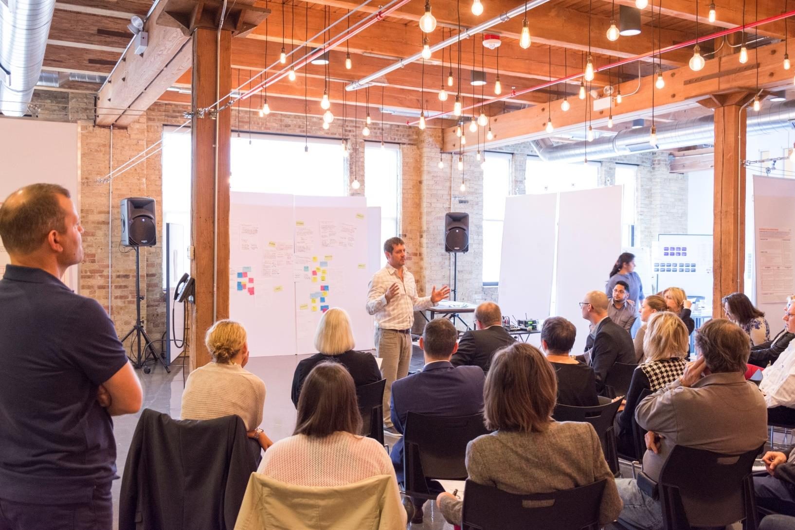 A speaker addressing a full room at a peergroup gathering
